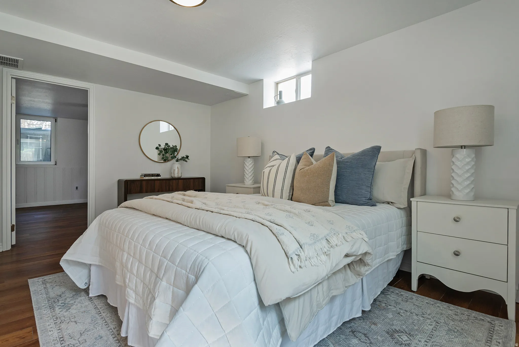 Recessed lighting, wood flooring, white walls, and a window providing natural light