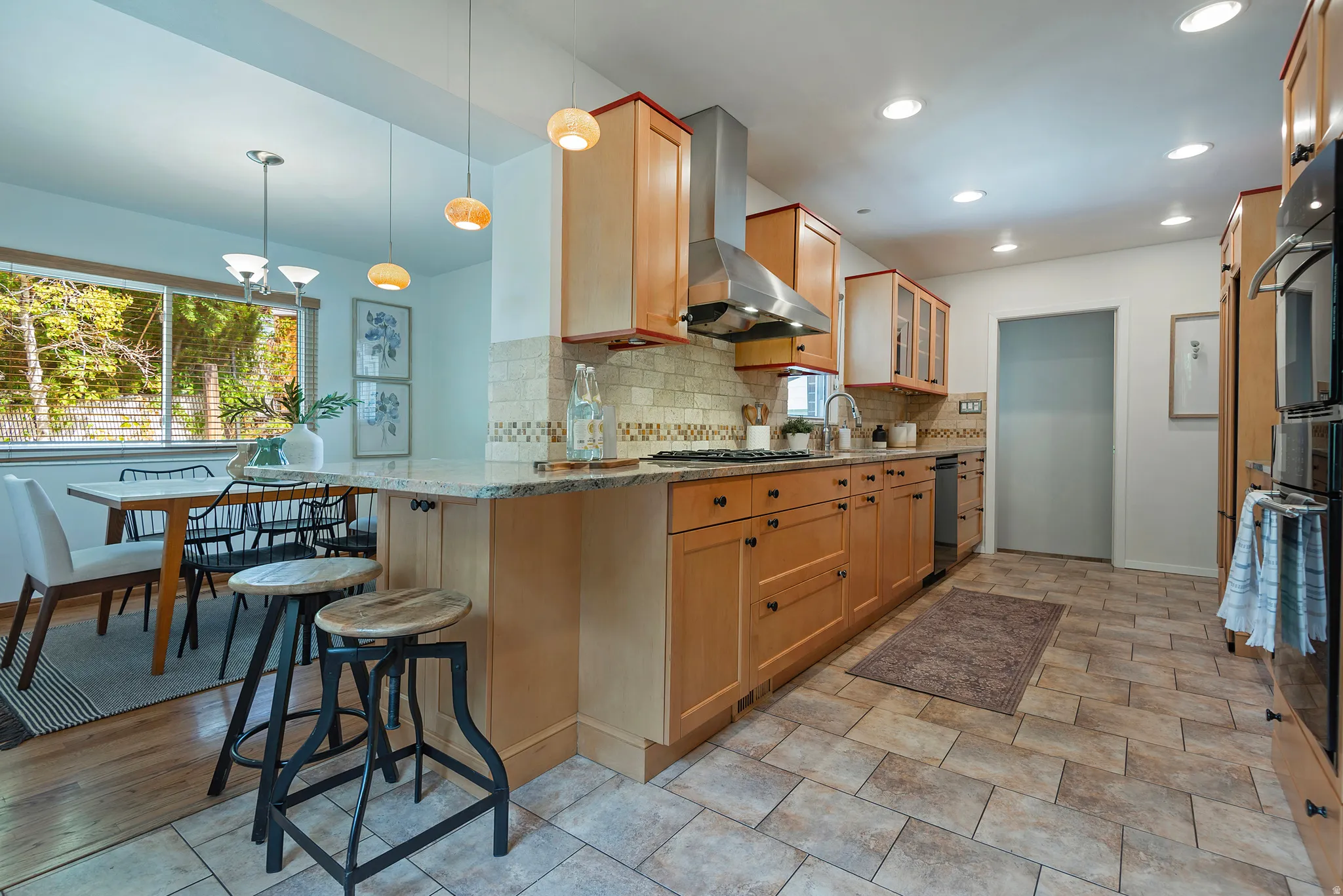 Kitchen featuring wood cabinetry, stone-finish countertops, stainless steel appliances, and a tile backsplash