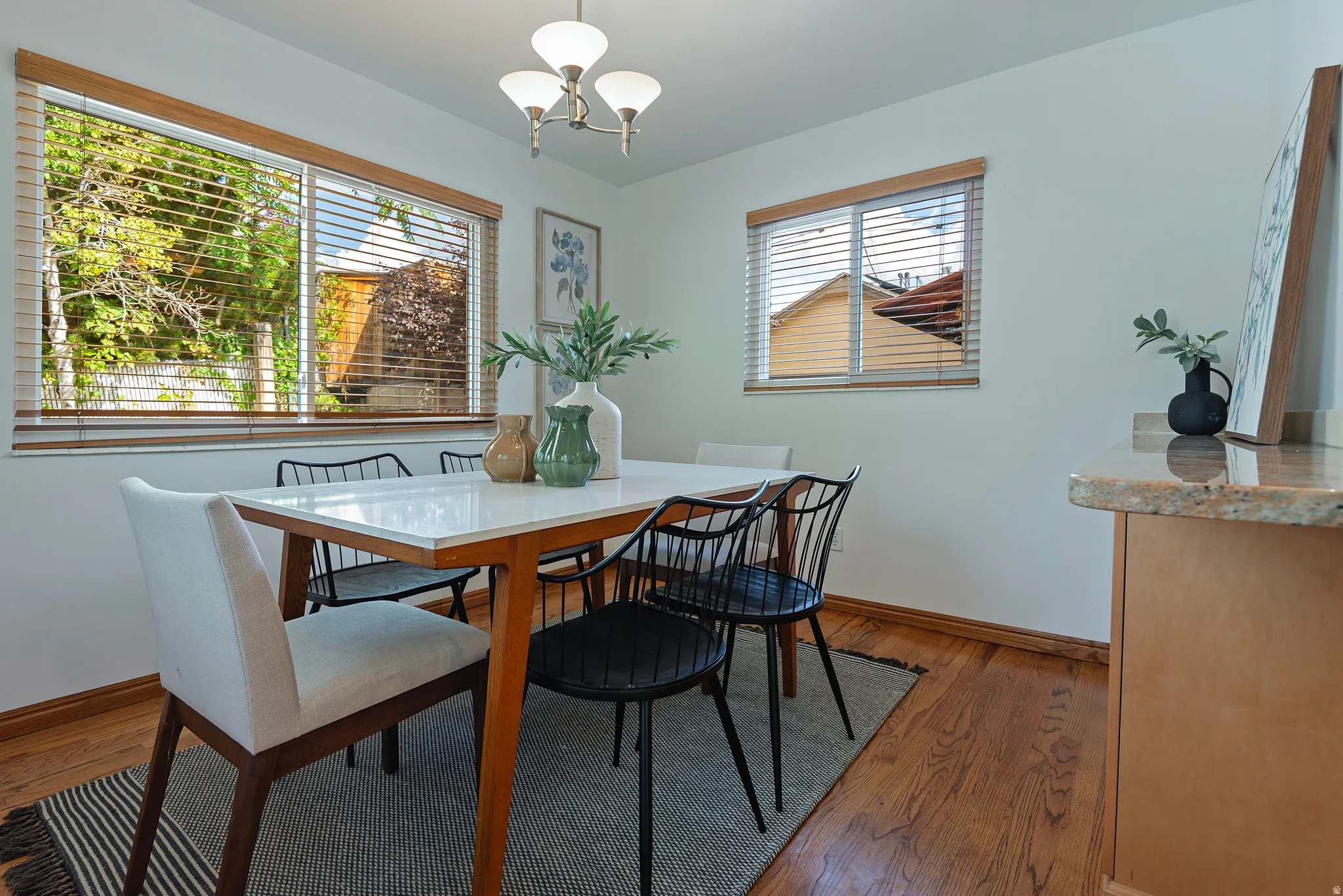 Wood flooring, white walls, and wood-framed windows with blinds