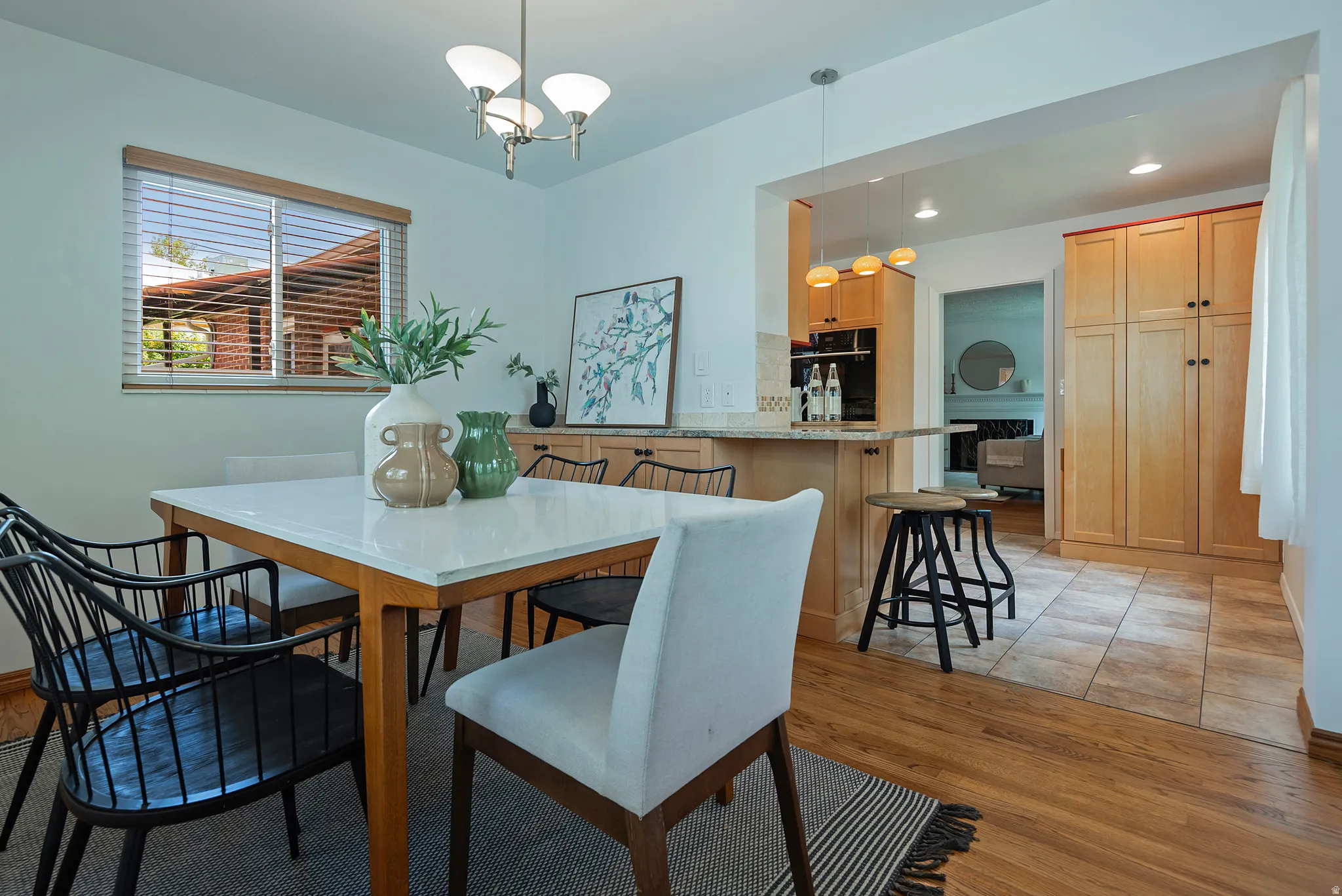 Hardwood flooring, overhead chandelier, window with blinds, recessed lighting, and built-in cabinetry