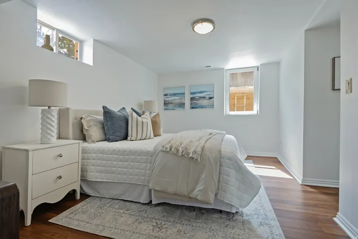 Recessed ceiling lighting, wood flooring, and white baseboard trim
