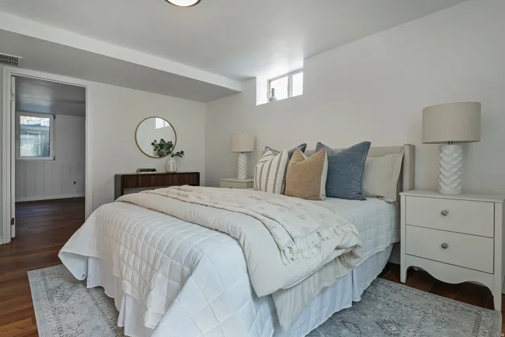 Recessed lighting, wood flooring, white walls, and a window providing natural light
