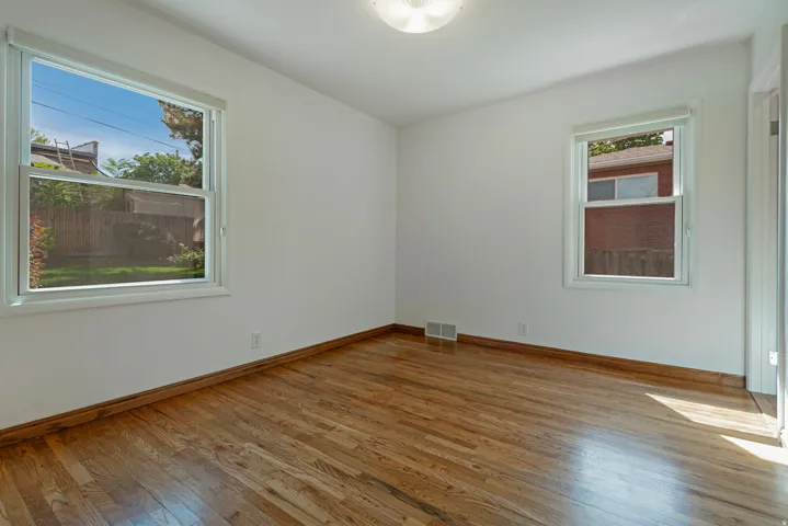 Hardwood flooring, two windows, white walls, white trim, flush mount ceiling light