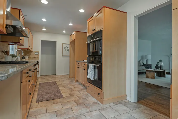 Kitchen featuring light wood cabinetry, stone countertops, and tile flooring