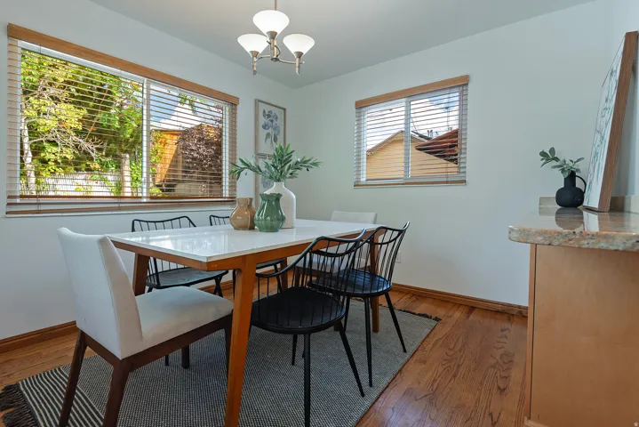 Wood flooring, white walls, and wood-framed windows with blinds