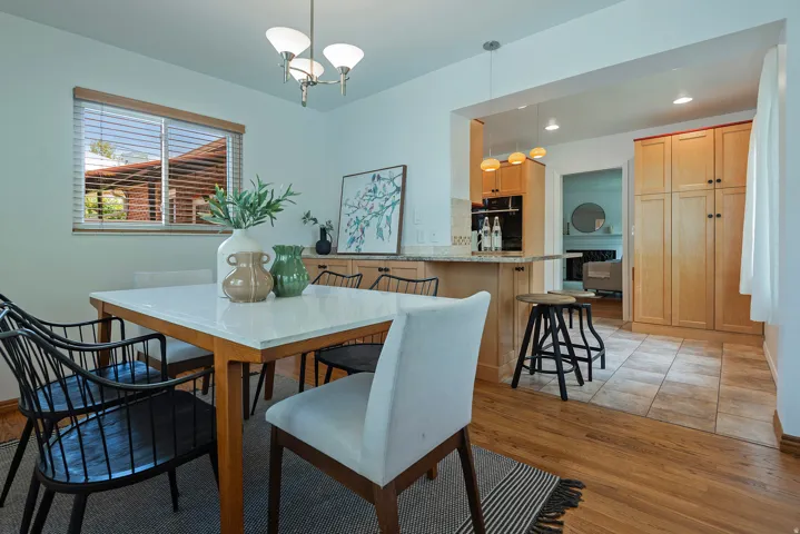 Hardwood flooring, overhead chandelier, window with blinds, recessed lighting, and built-in cabinetry