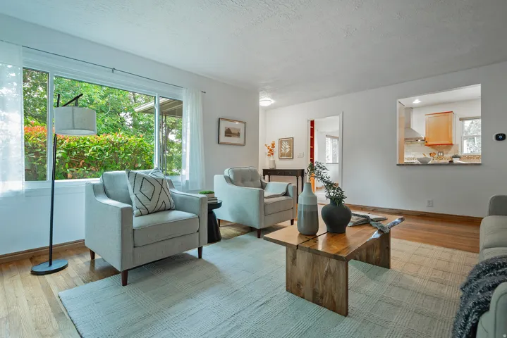 Wood flooring throughout, bright white walls, and a pass-through window to the kitchen