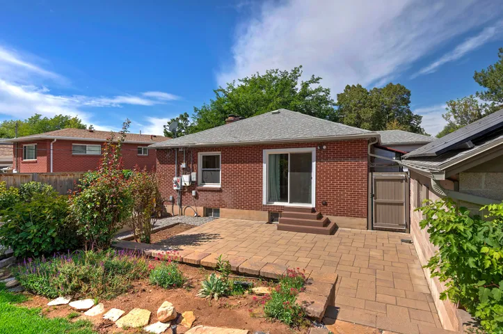Brick exterior, sliding glass door, paver patio, wood-finish stairs, privacy gate