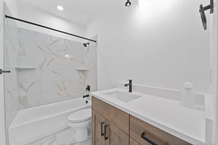 Integrated tub and shower with tiled surround and built-in niches
