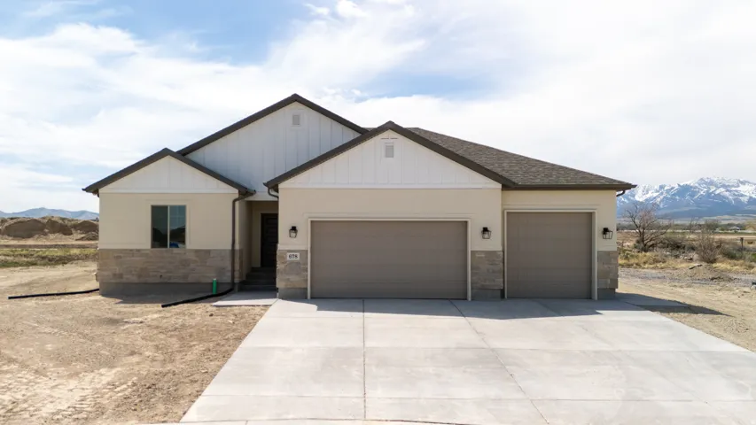 Contemporary single-story residence with a two-car garage, stucco exterior, and stone accent detailing