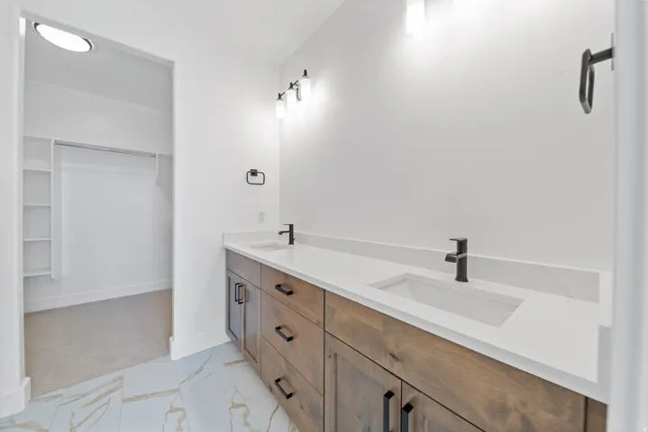 Double vanity with wood-finish cabinetry and white countertops
