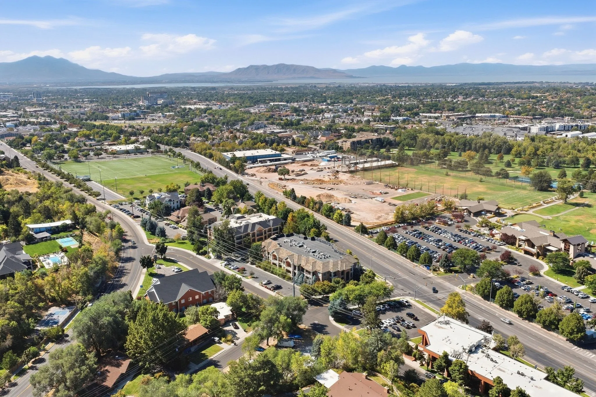 Expansive urban landscape with a distant lake and mountain backdrop