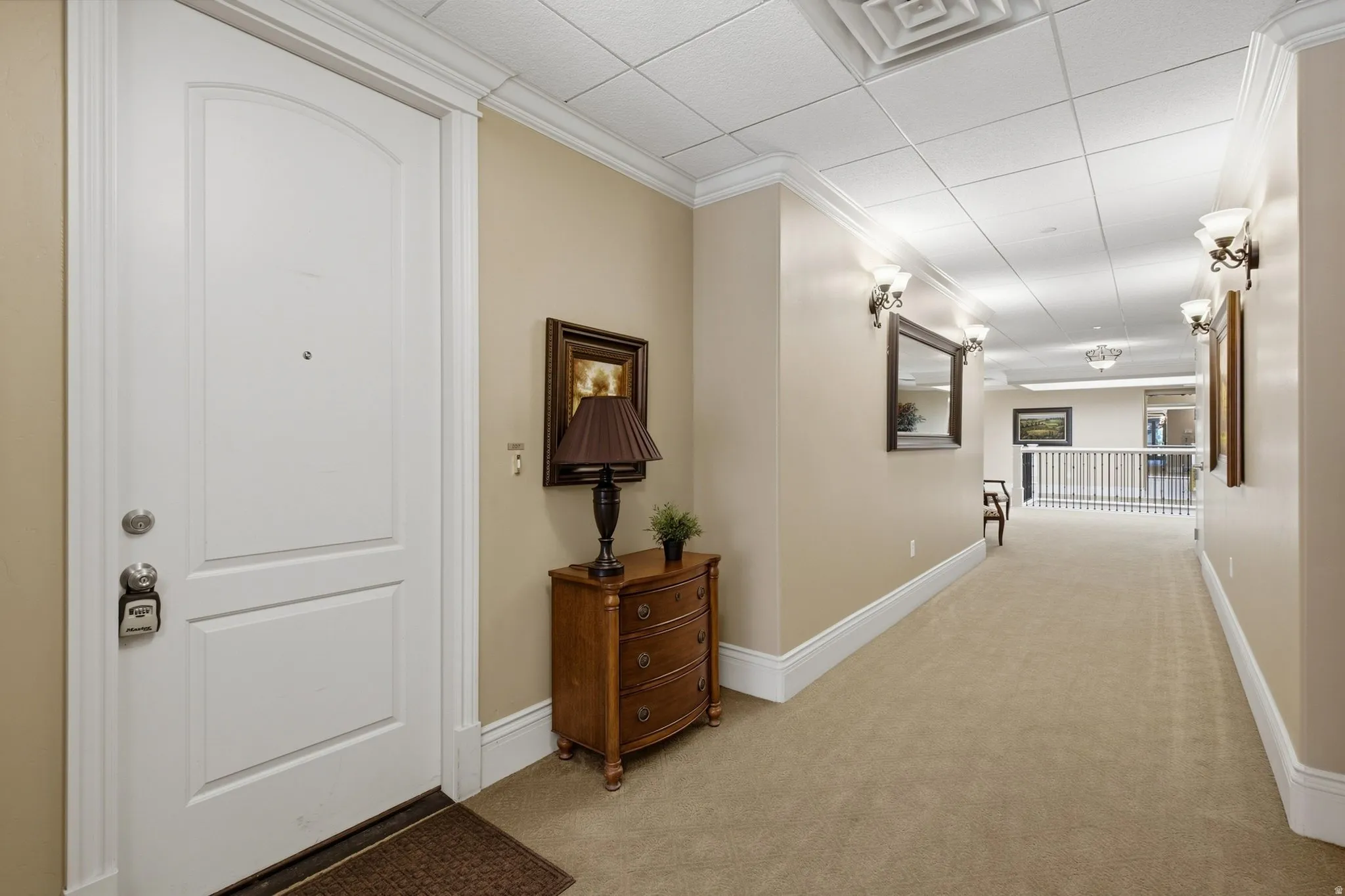 Arched panel entry door with crown molding and wall sconces