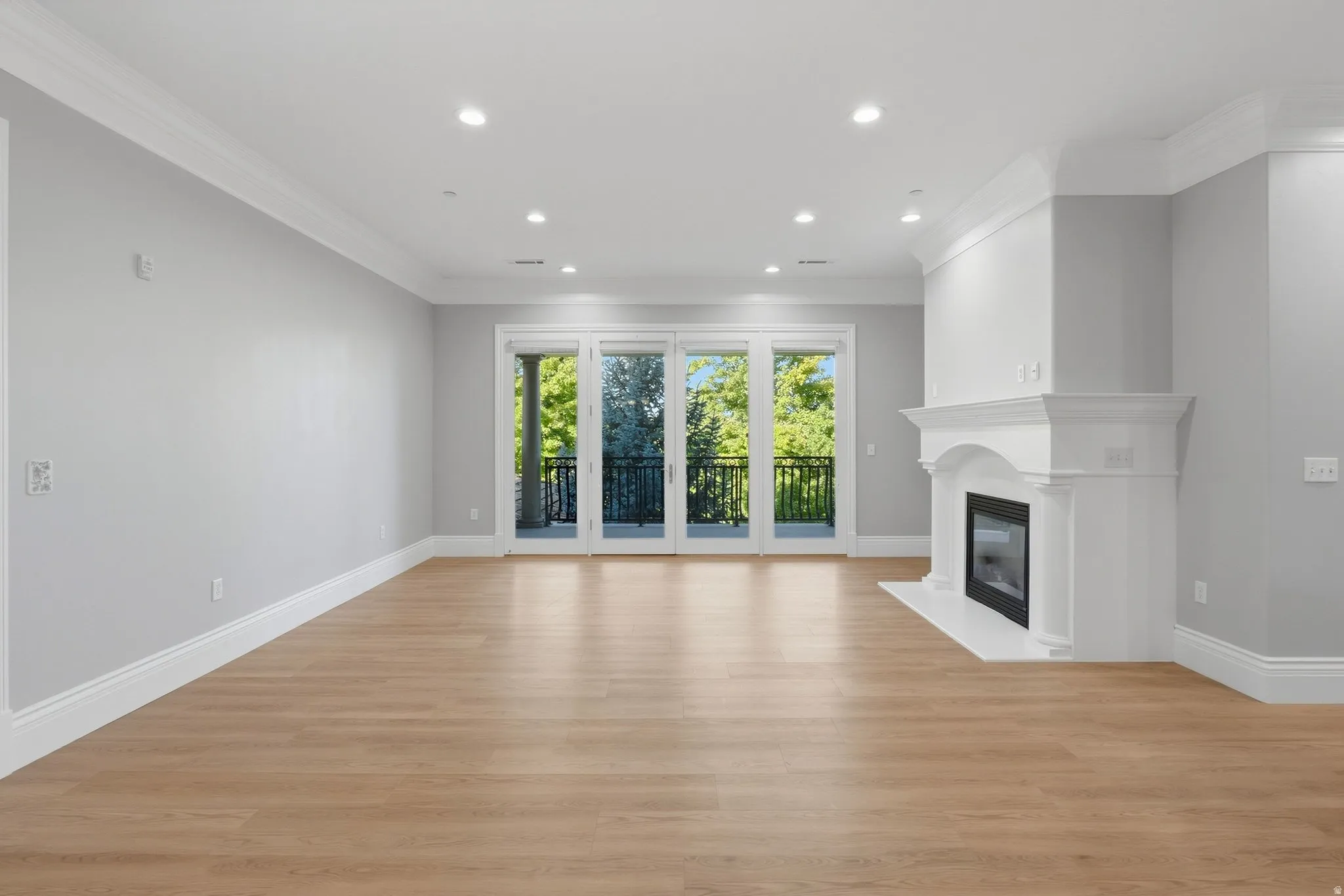 Hardwood-finish flooring throughout, featuring a white mantle fireplace with a dark-framed firebox