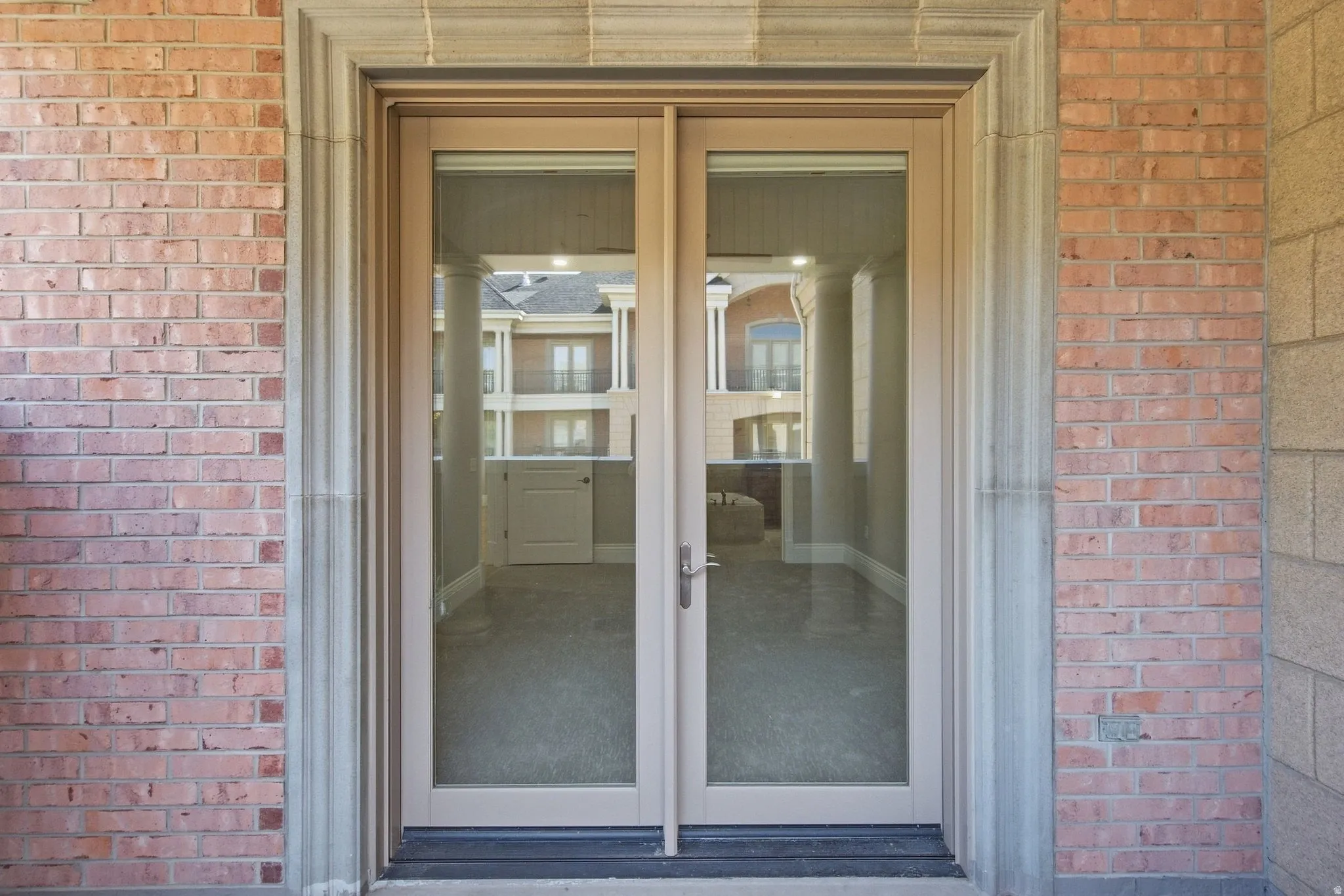 Brick exterior with a stone door surround and transom