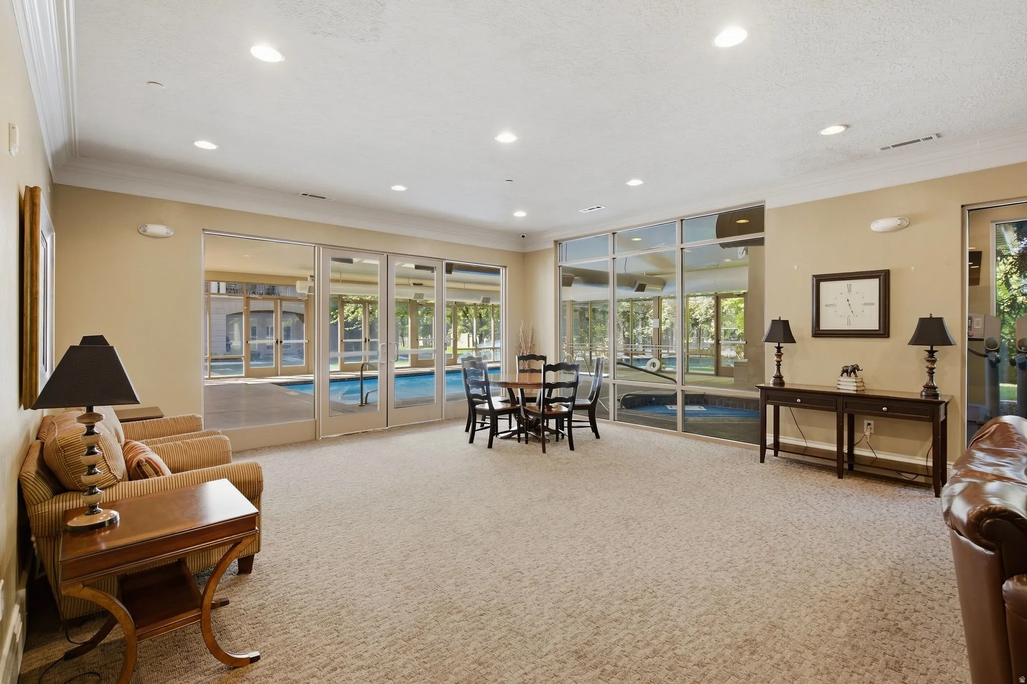 Recessed lighting throughout, crown molding, expansive glass panel doors, and neutral wall tones
