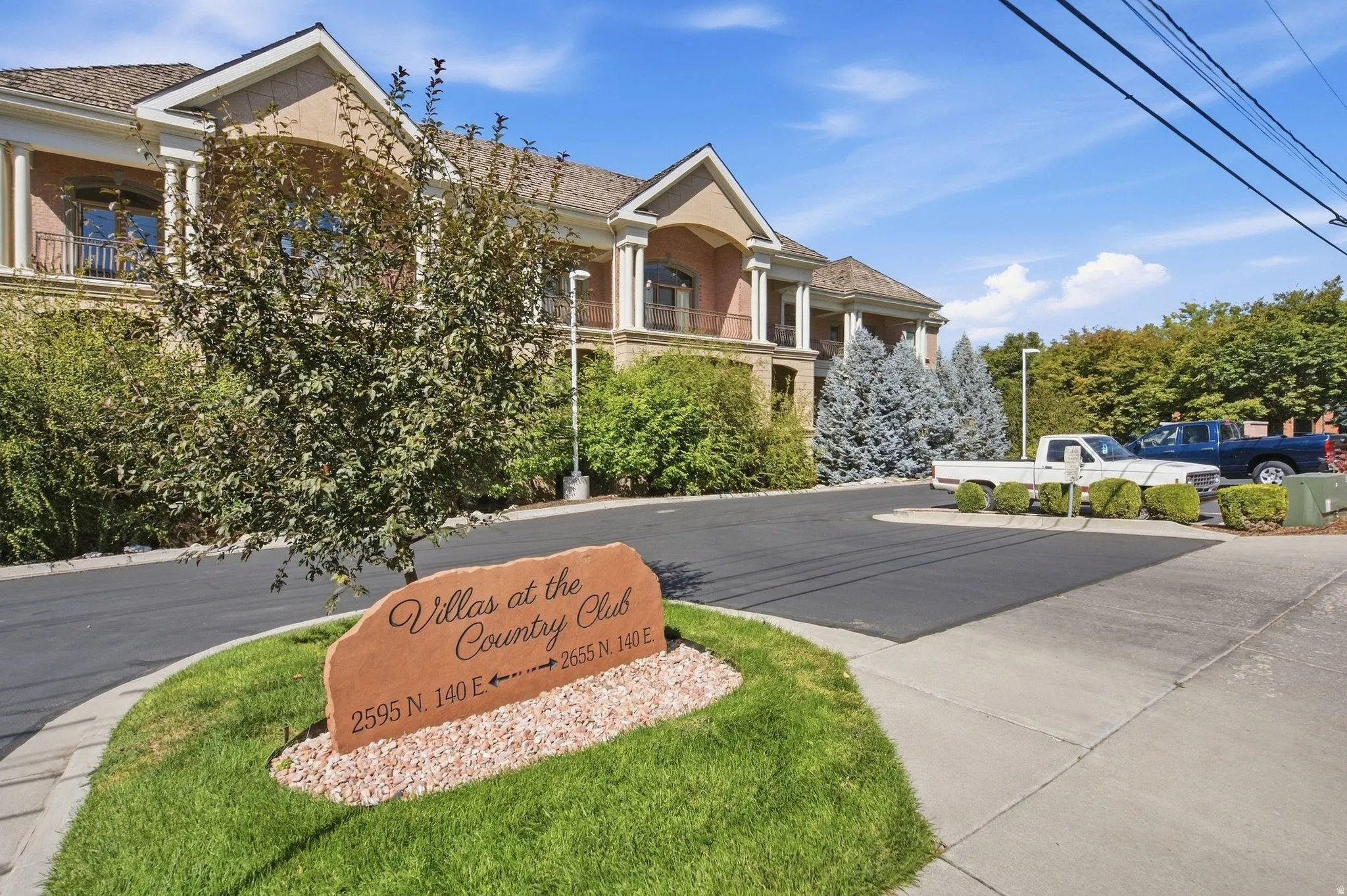 Stately residence with a prominent entryway, mature landscaping, and an asphalt driveway