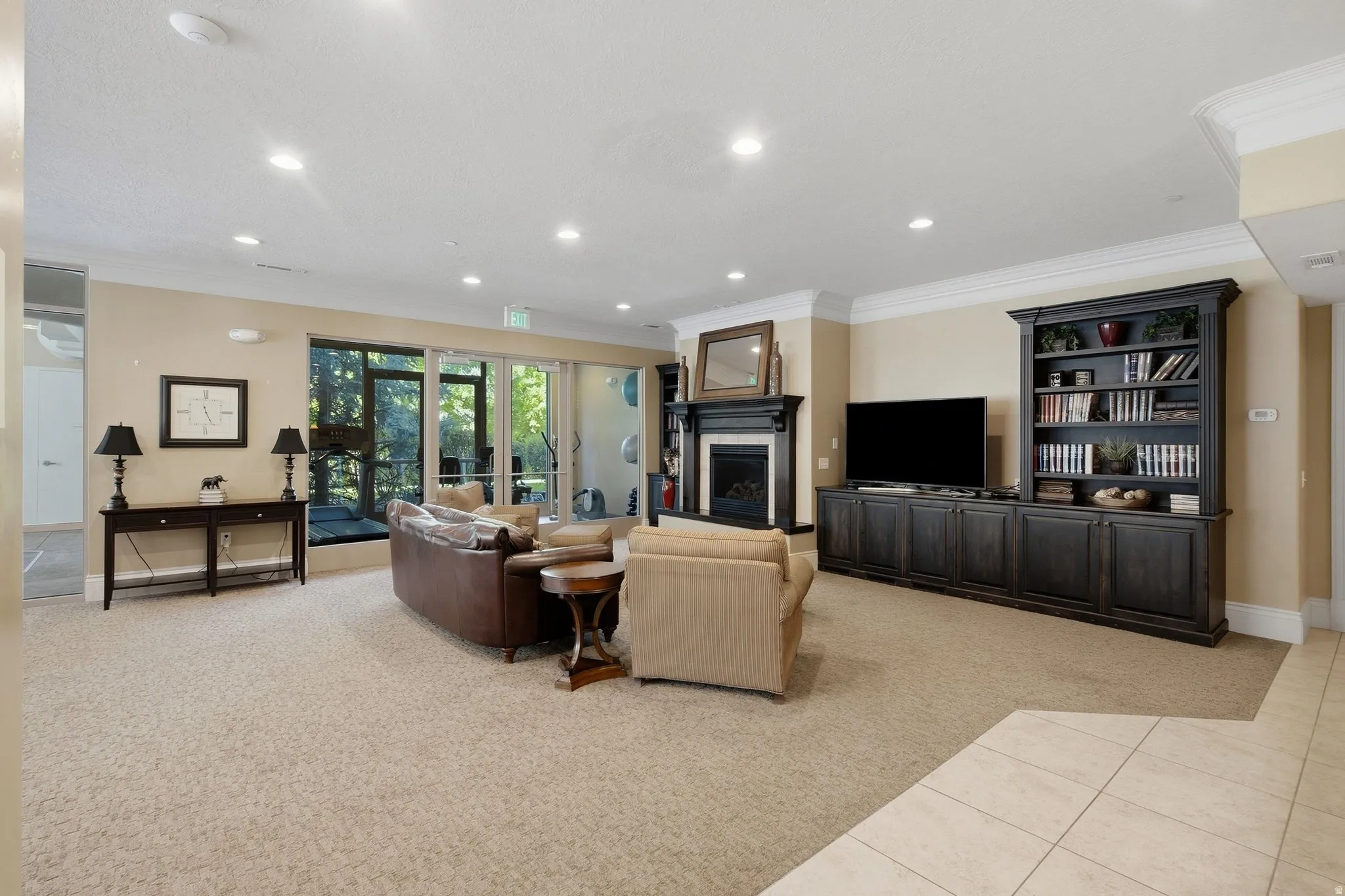 Recessed lighting, crown molding, and a fireplace with a dark wood mantel