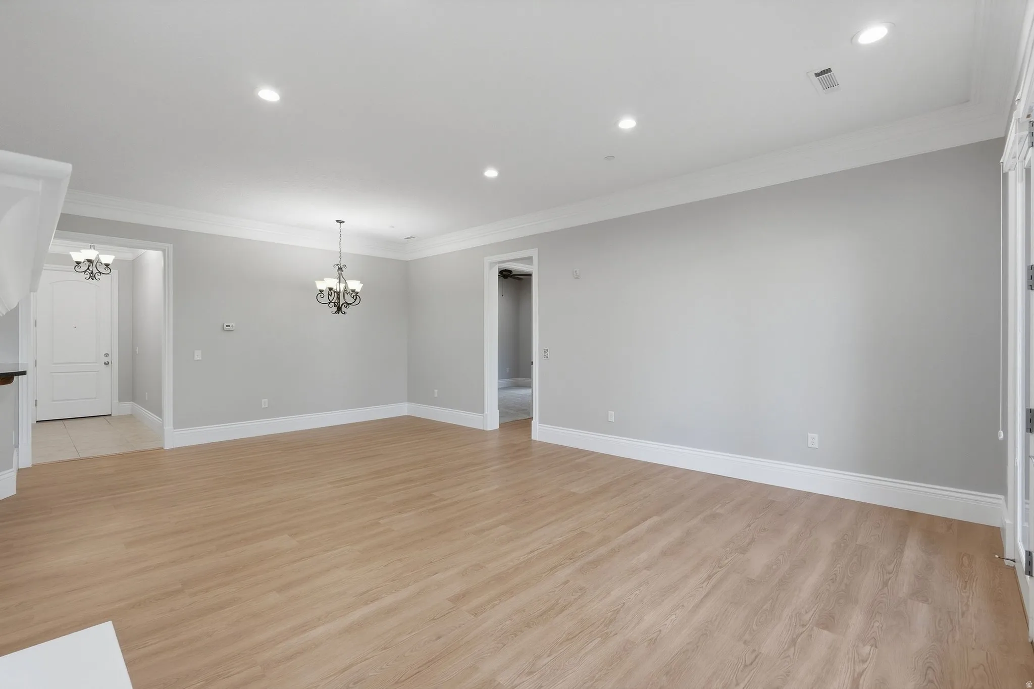 Wood-finish flooring throughout, recessed lighting, and crown molding