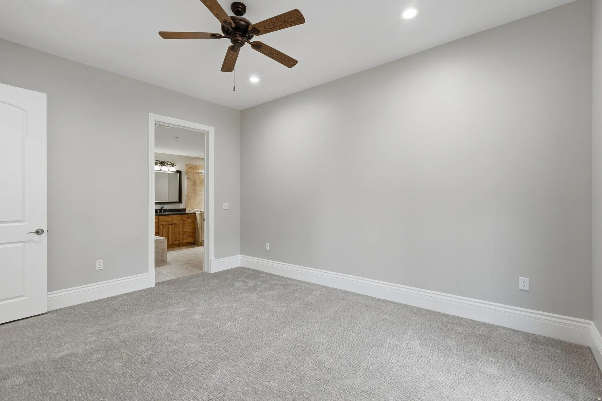 Recessed ceiling lighting, ceiling fan, neutral wall tones, and carpet flooring