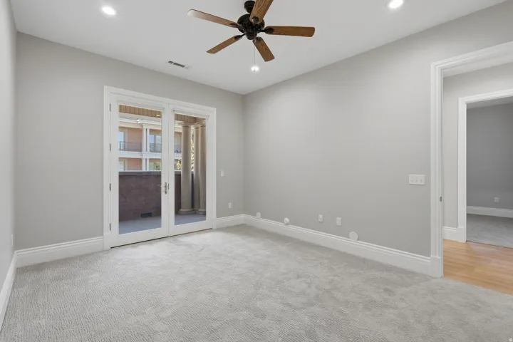 Recessed lighting, ceiling fan, double French doors, and light-toned carpeting