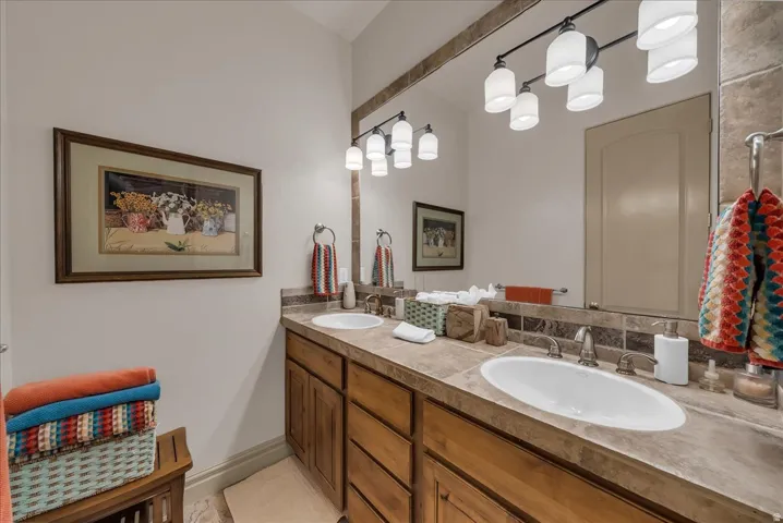 Double vanity with integrated sinks, wood-finish cabinetry, and a stone-finish countertop