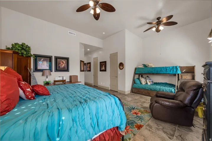 High ceilings featuring two ceiling fans, tile flooring, and light-toned walls