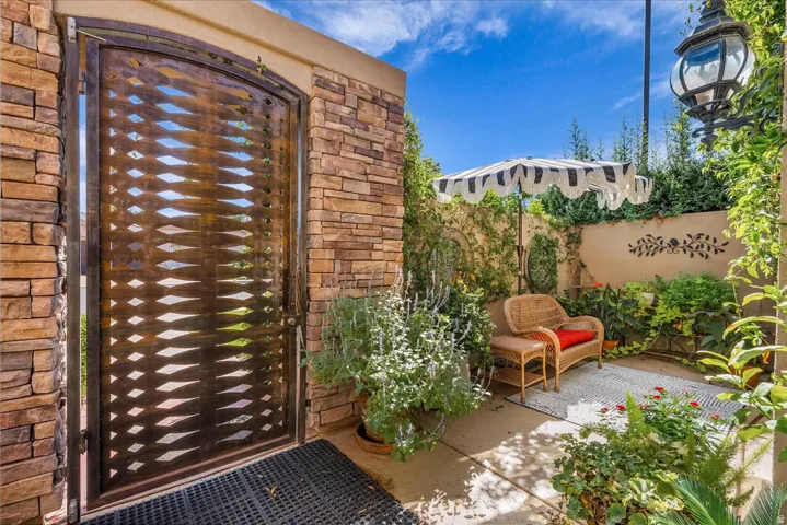 Private courtyard entry featuring a decorative metal gate and stone wall