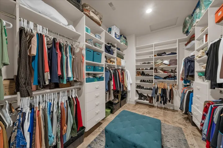 Extensive built-in closet system with multiple shelving units, hanging rods, and integrated drawers