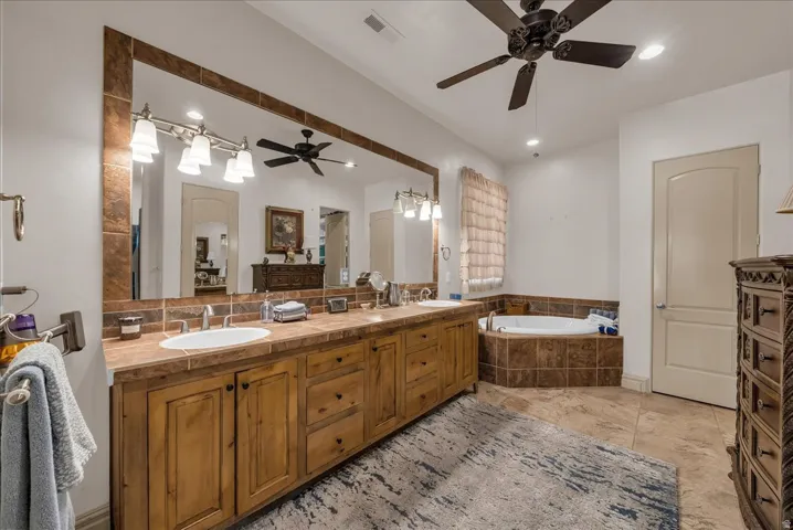 Dual vanity with integrated sinks, wood-finish cabinetry, and a large framed mirror