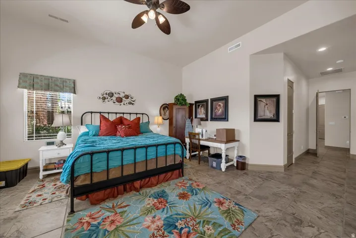 Vaulted ceiling, ceiling fan, window with blinds, tile flooring, and recessed lighting