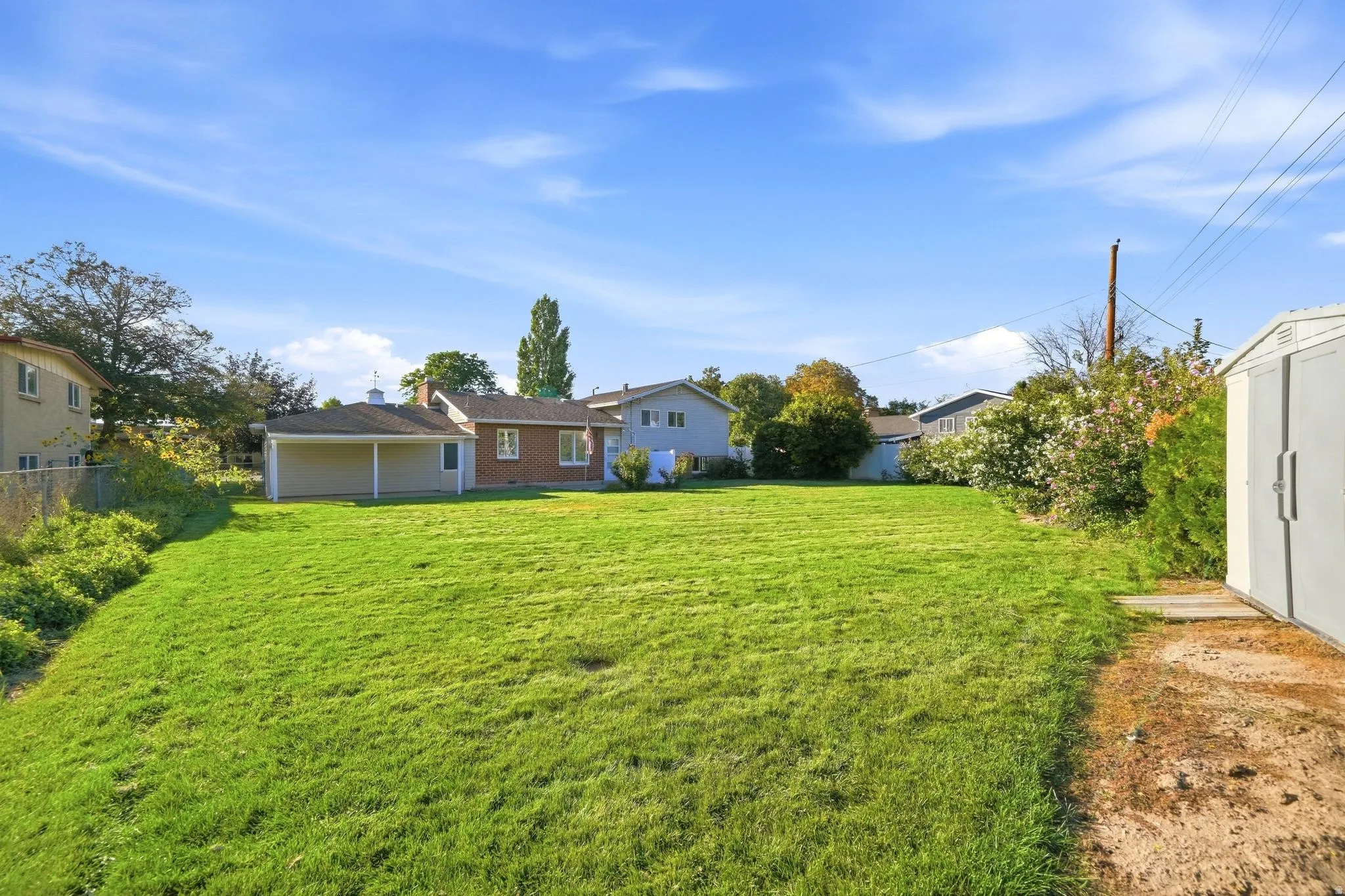 Expansive green lawn with a detached storage shed