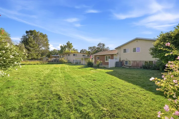 Expansive grassy lawn with mature perimeter landscaping