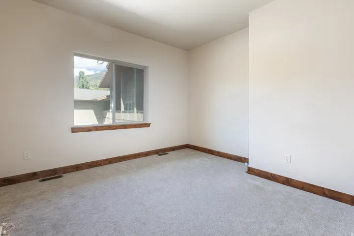 Expansive room with neutral carpeting and light-toned walls