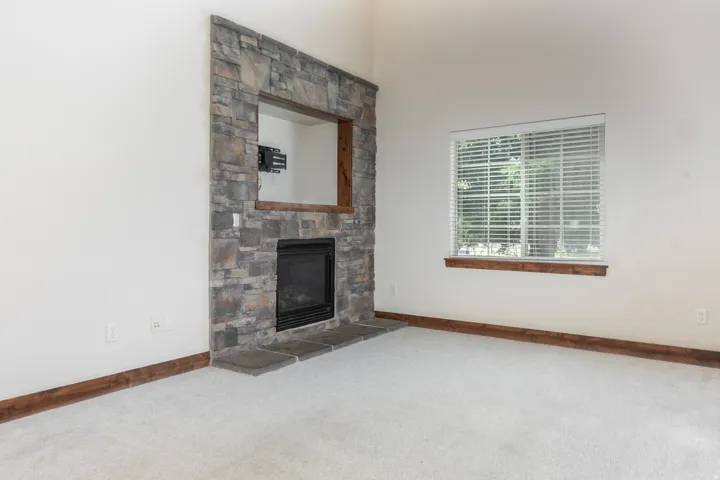 Stone-clad fireplace with a recessed media niche, integrated firebox, and stone hearth