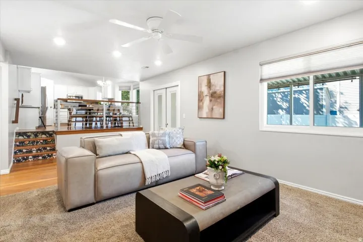 Recessed lighting, ceiling fan, carpet flooring, large window, and wood-finish flooring