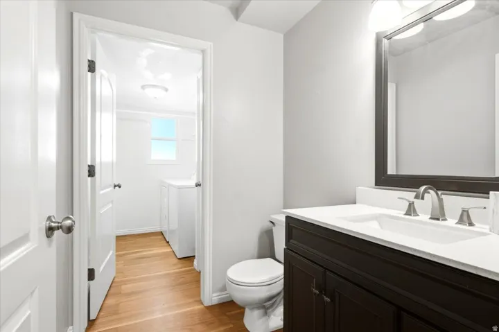 Vanity with dark wood-finish cabinetry, white countertop, and brushed nickel faucet