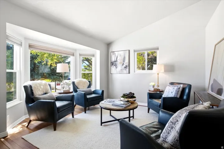 Bay window with multiple glass panes, wood-finish flooring, vaulted ceiling, and recessed window