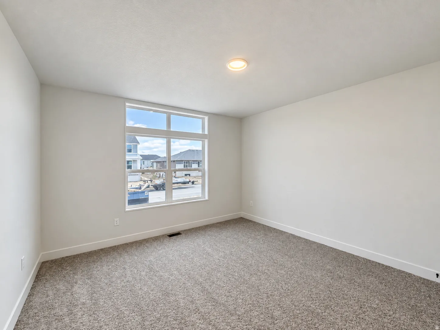 Expansive window offering abundant natural light, neutral wall colors, recessed ceiling lighting, and plush carpet flooring