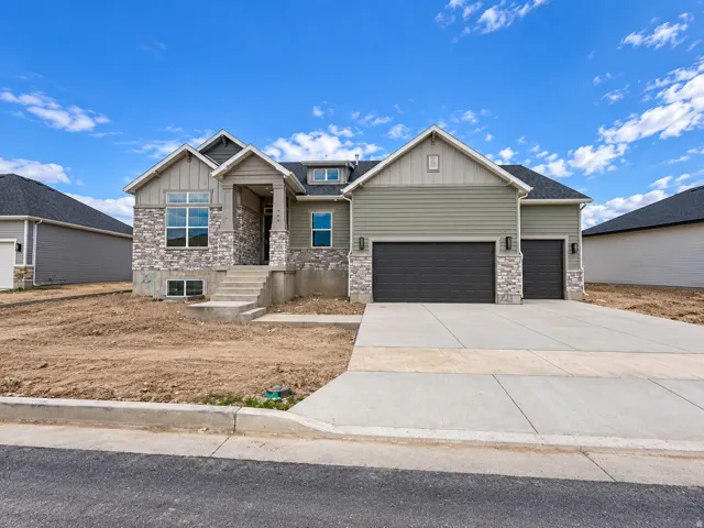 Exterior featuring stone veneer and horizontal siding, an attached two-car garage, a covered entry, and a concrete driveway