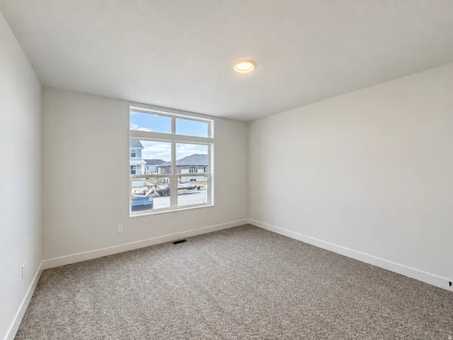 Expansive window offering abundant natural light, neutral wall colors, recessed ceiling lighting, and plush carpet flooring