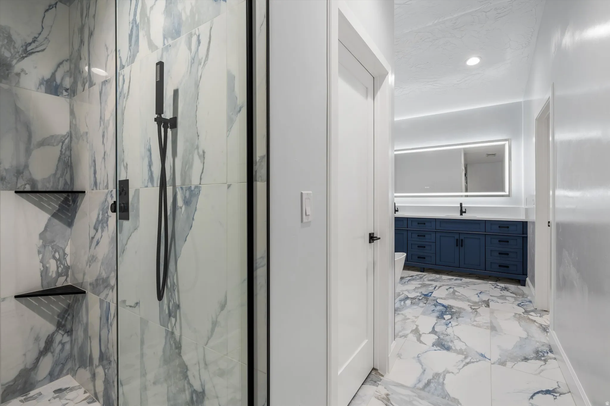 Spacious shower with large format wall tiles and black fixtures