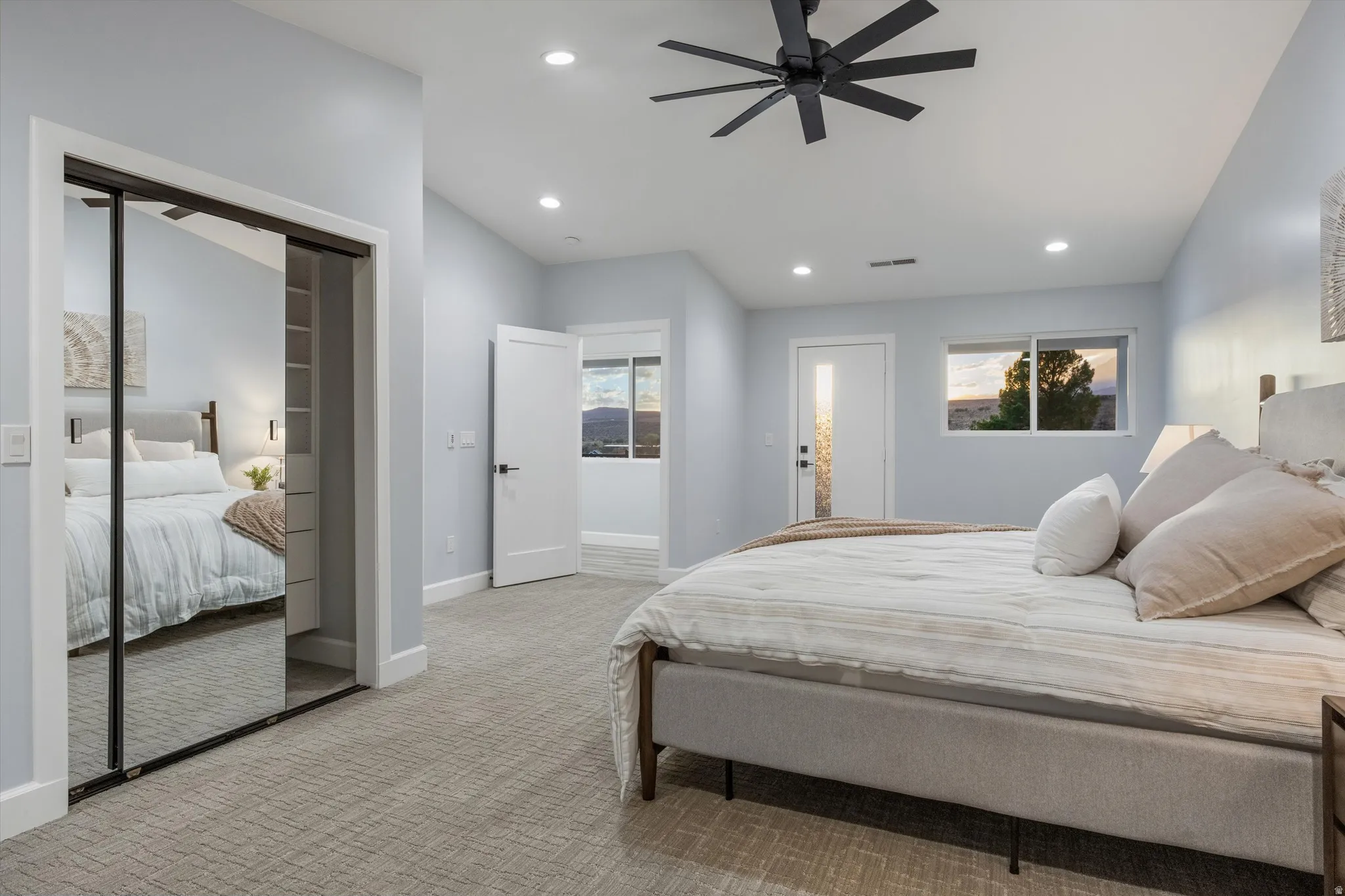Recessed ceiling lighting, a contemporary ceiling fan, and a built-in closet with sliding mirrored doors