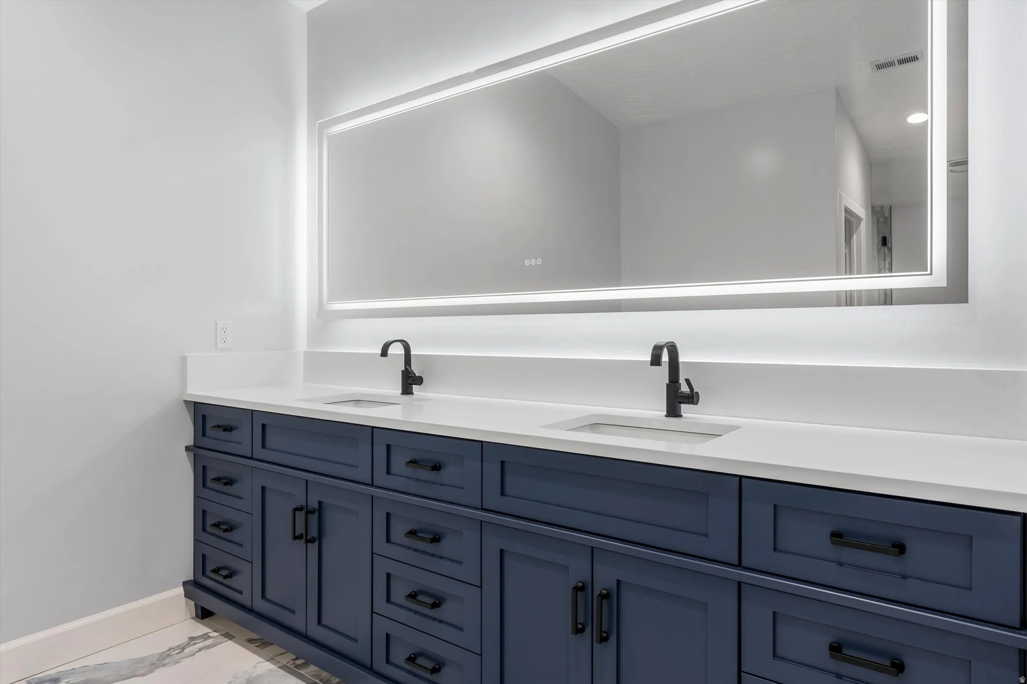Dual vanity with a white countertop and integrated sinks