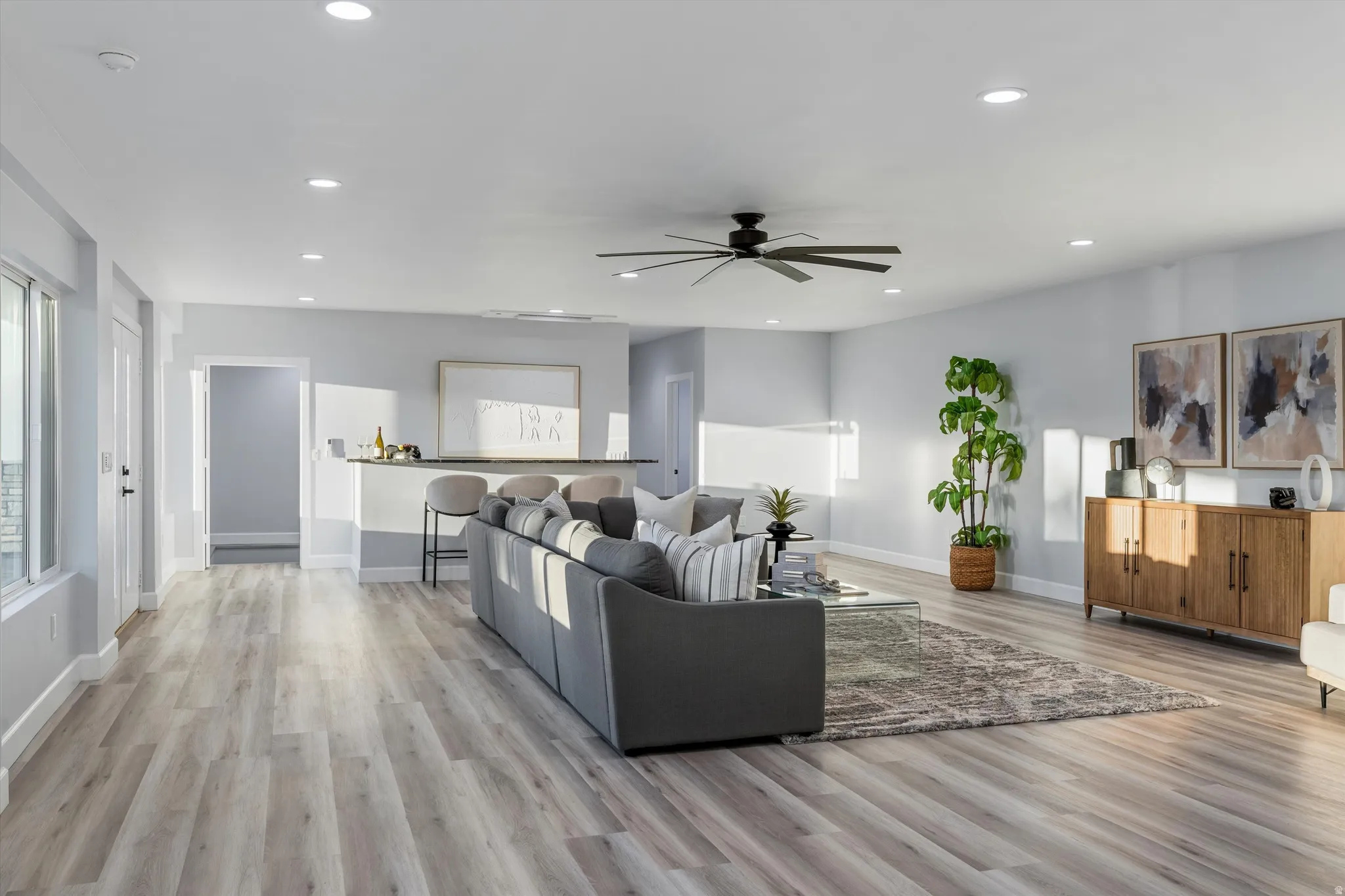 Spacious living area featuring wood-finish flooring, recessed lighting, and a modern ceiling fan