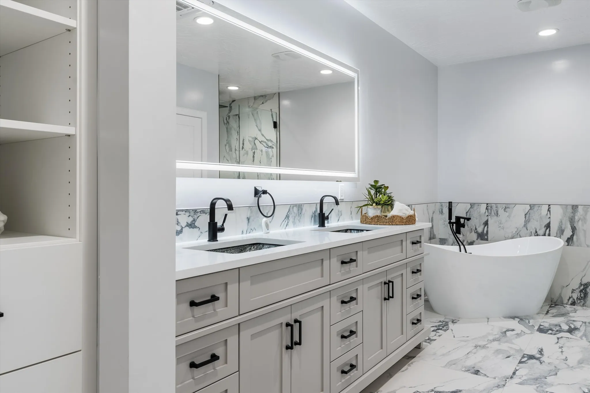Dual vanity with white countertops, matte black fixtures, and light gray cabinetry