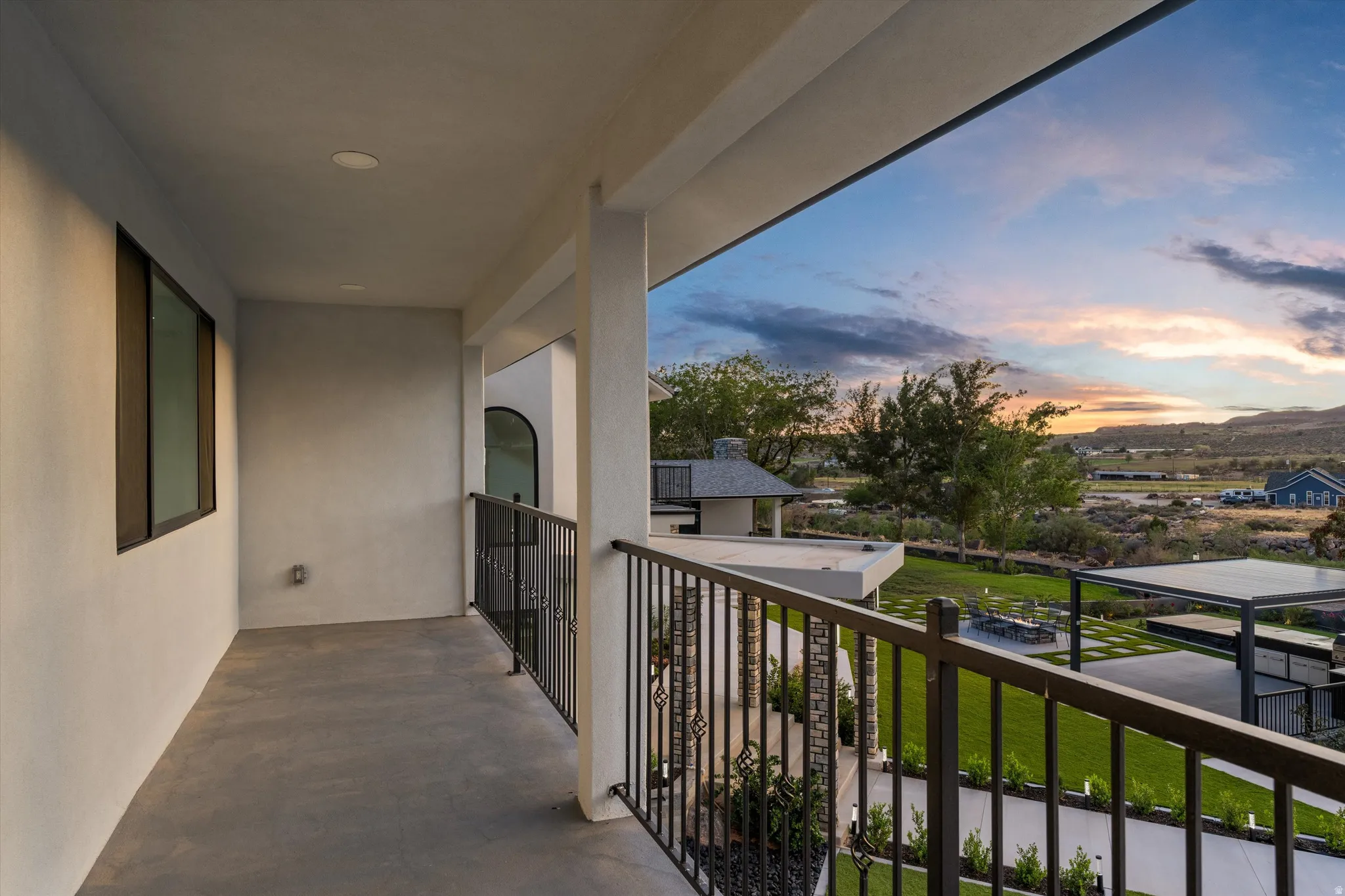 Balcony with a sturdy metal railing, recessed lighting, and a broad window