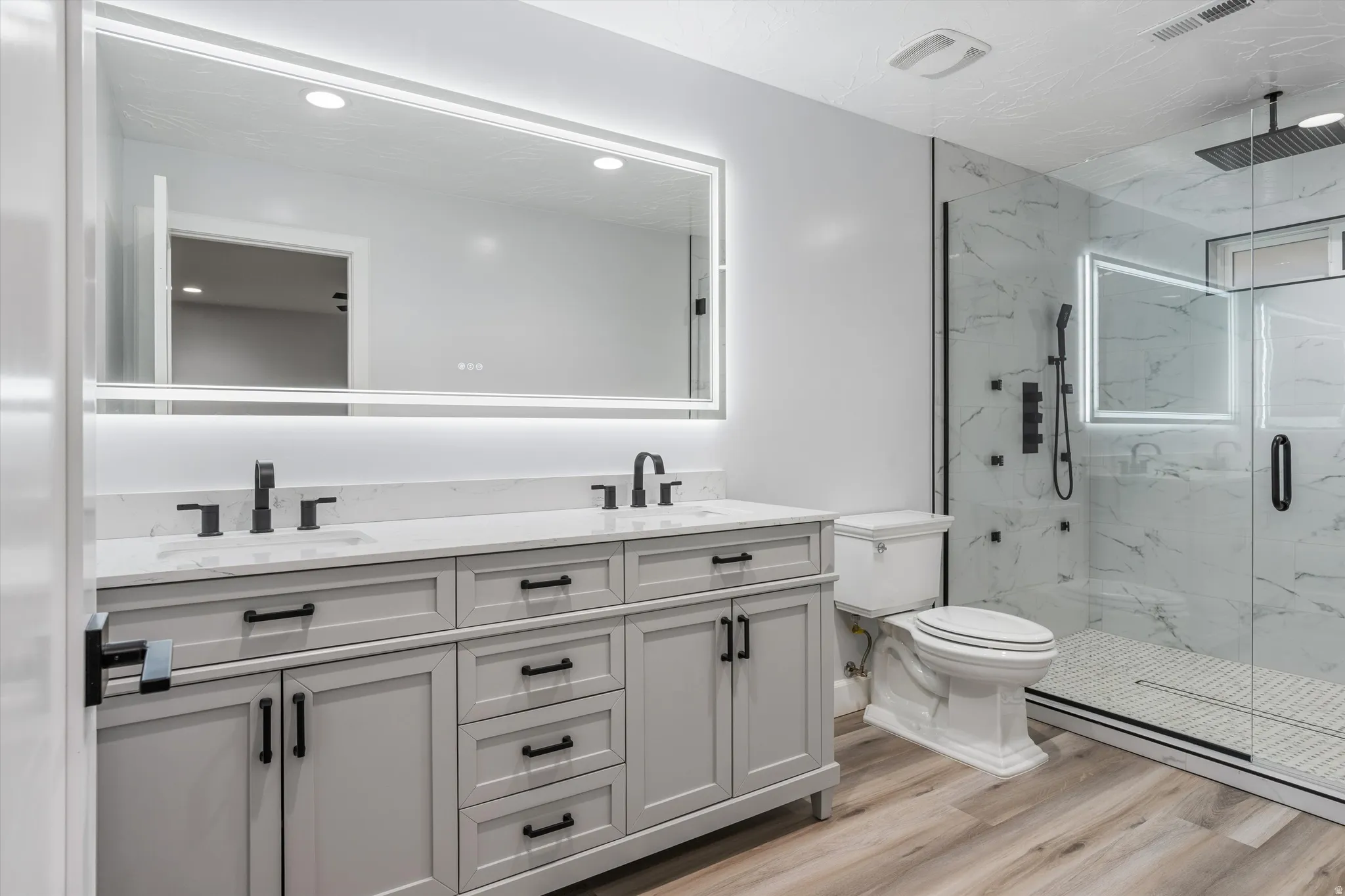 Double vanity with light gray cabinetry and matte black hardware