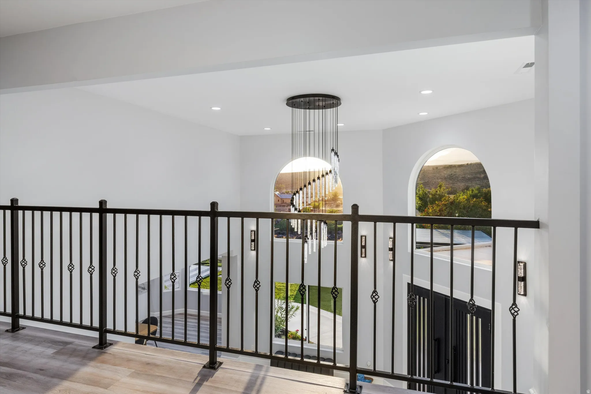 Open-concept upper level with an ornate wrought-iron railing and wood-finish flooring