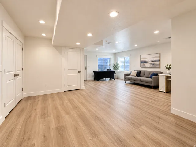 Recessed lighting, wood-finish flooring, white paneled doors, and two daylight windows with white plantation shutters